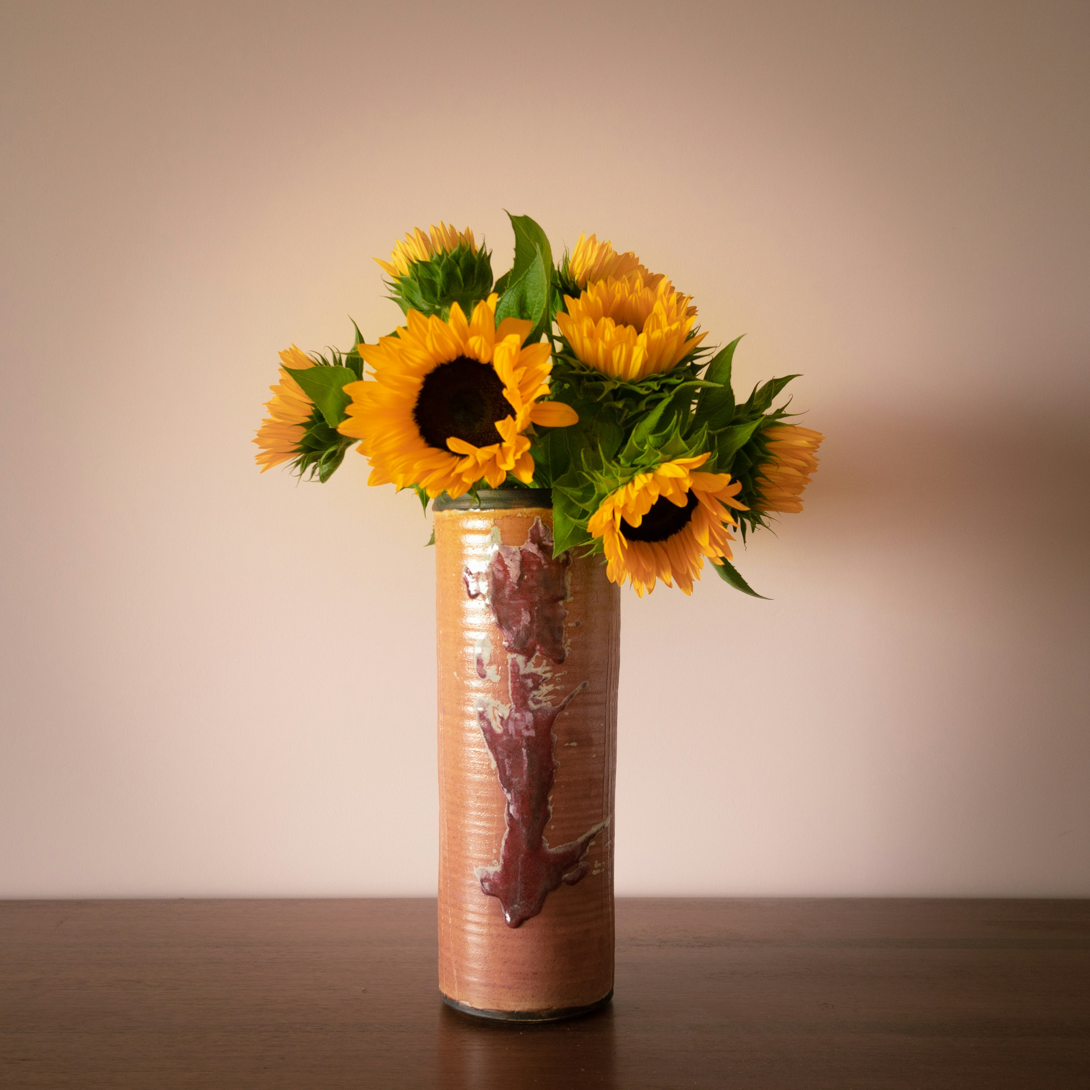 yellow sunflower in purple and white floral vase